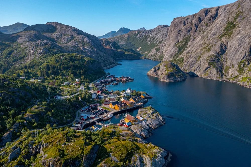 Aerial view of Nusfjord village and fjord surrounded by rugged mountains