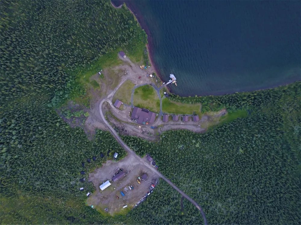 Aerial view of Inconnu Lodge compound nestled by a lake and forest