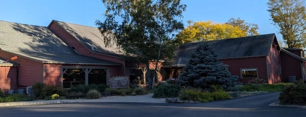 Exterior shot of the entrance to The Shops at The Emerson. Red building with the brown silo