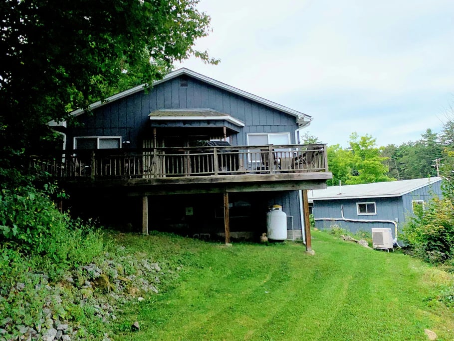 Blue Lake View Cottage with a white door, large windows, and a picnic table