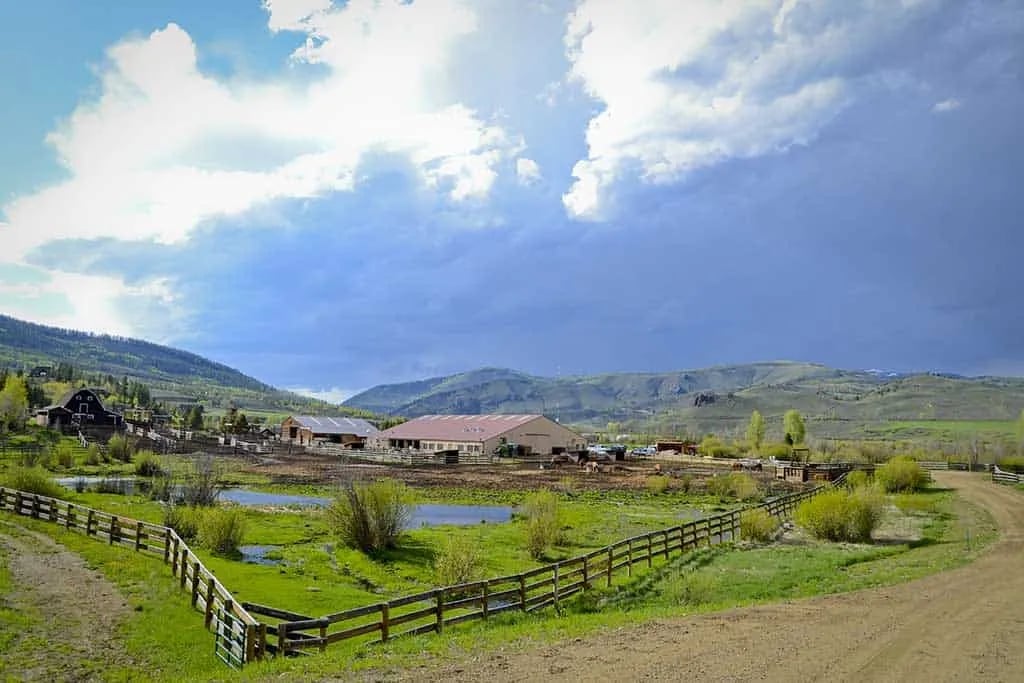 Panoramic overview of C Lazy U Ranch compound nestled in a green valley.