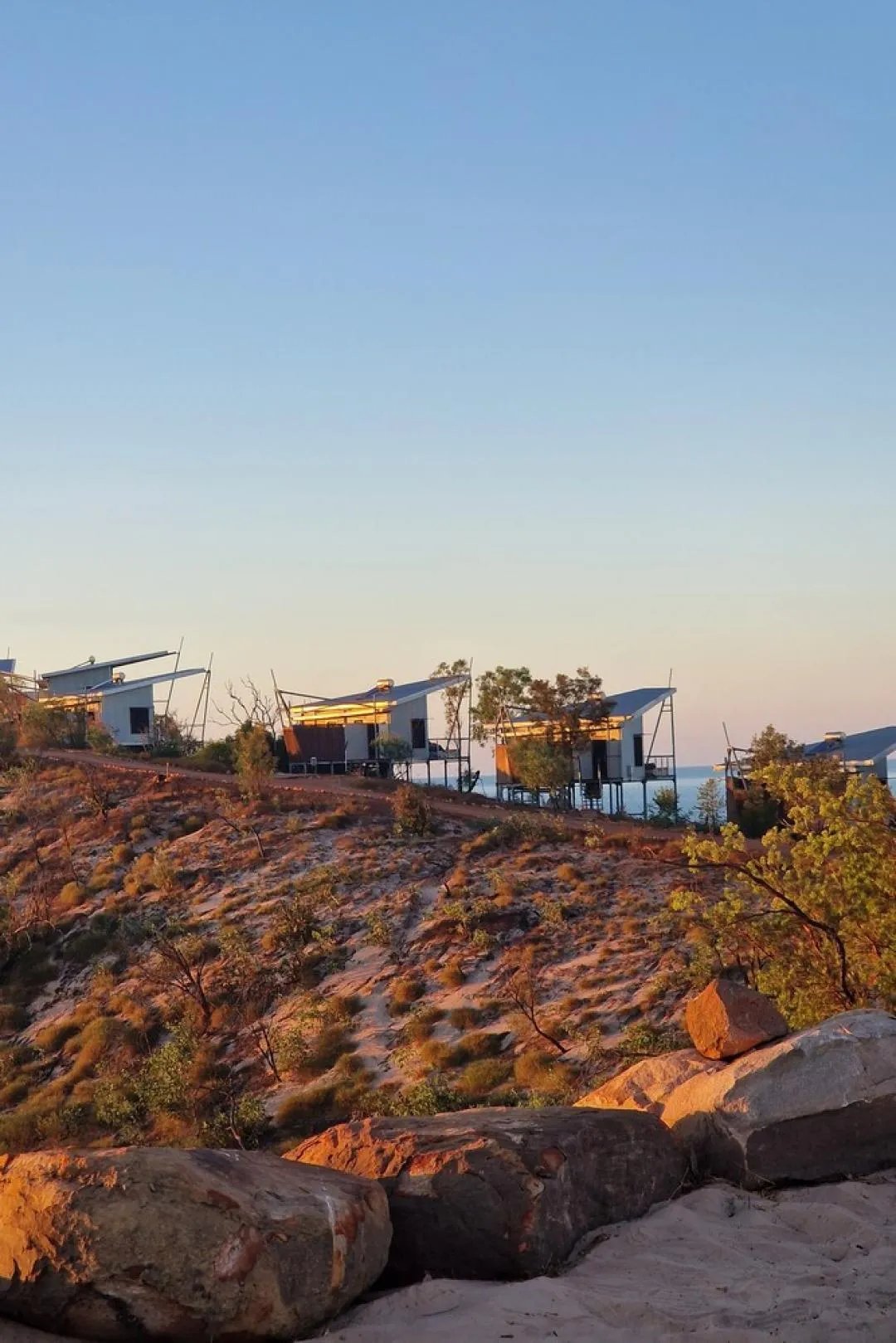 Row of luxury villas nestled on a golden hillside at sunset
