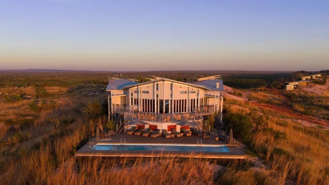 Aerial view of Berkeley River Lodge and infinity pool overlooking the ocean at sunset