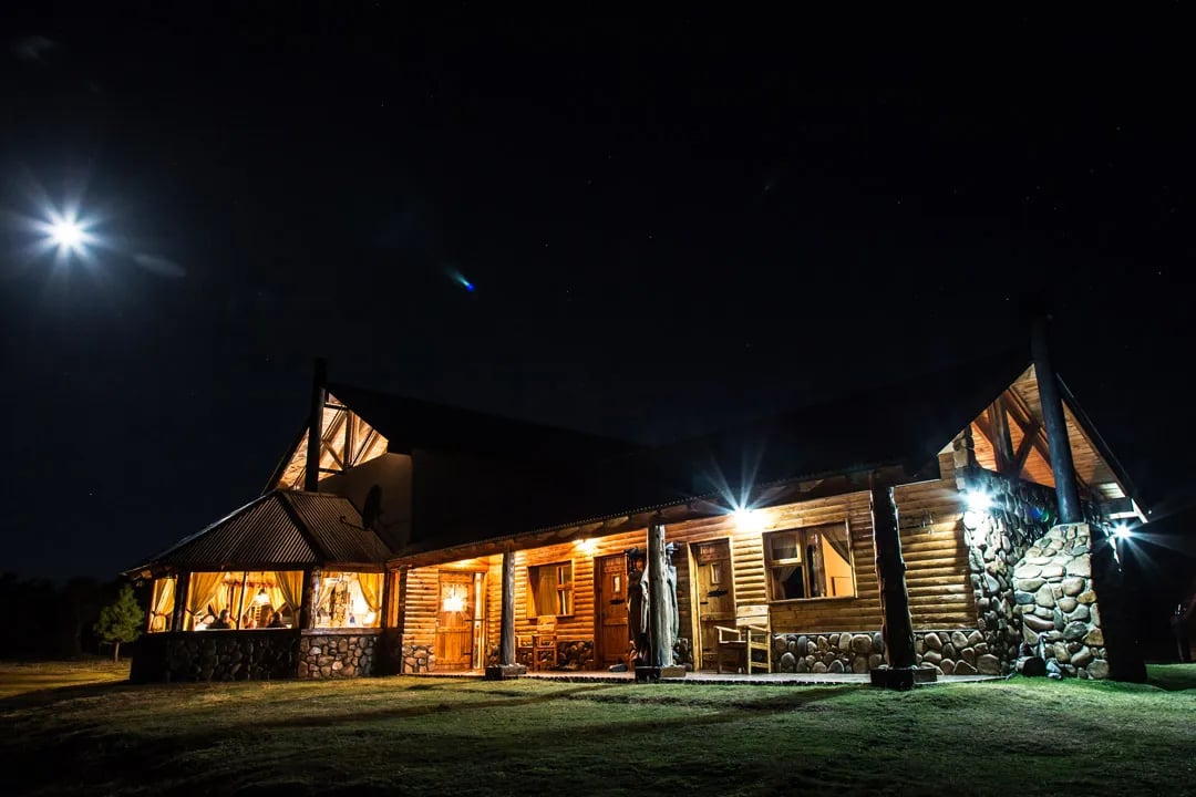 Lodge exterior illuminated at night under a starry sky, with warm lights glowing from inside.