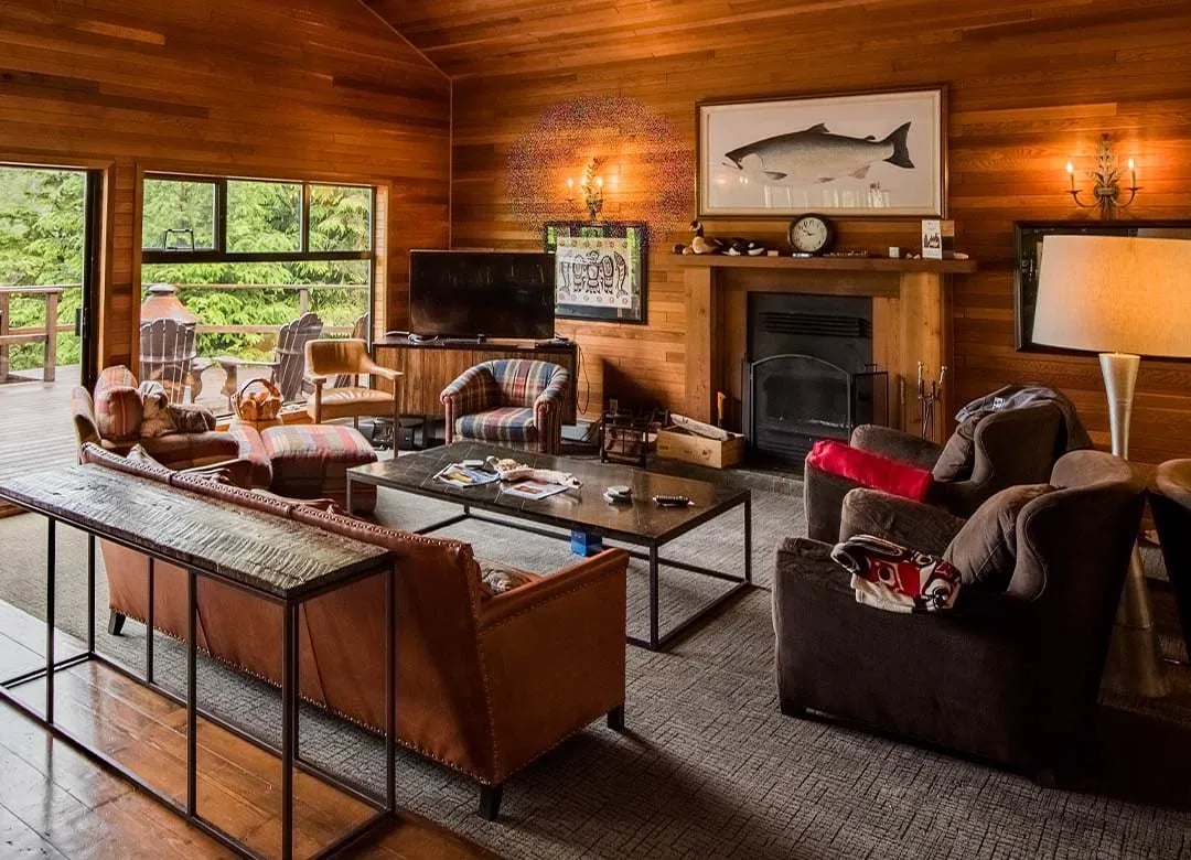 the west coast fishing club accommodations - lounge area with couches and fireplace
