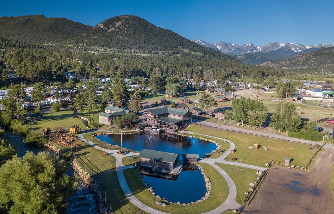Aerial view of the Trout Haven Resorts complex with multiple buildings, ponds, and mountains.