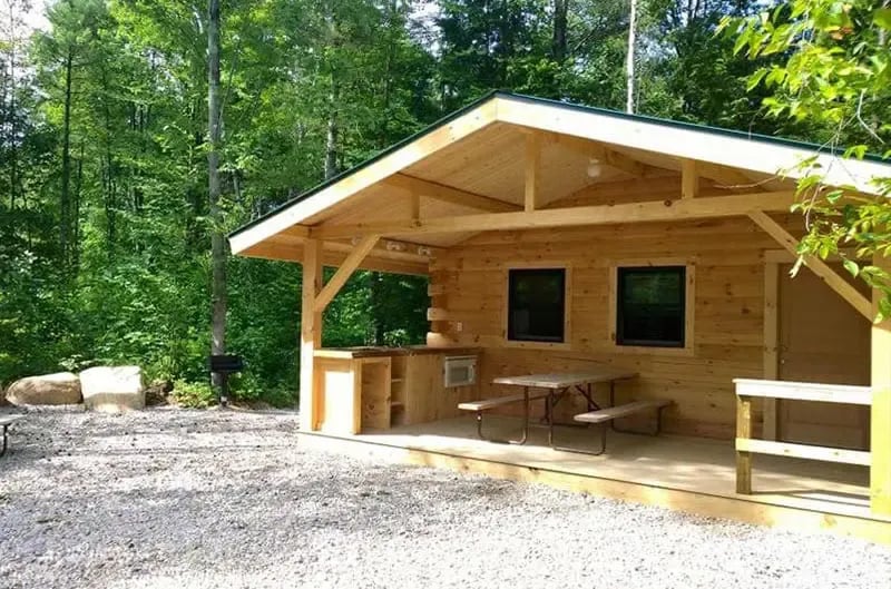 Deluxe cabin exterior with a large picnic table and steps leading to the entrance