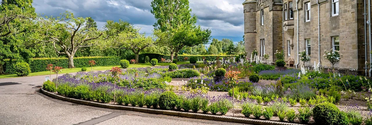 Rothes Glen castle exterior with extensive manicured gardens and a circular driveway.