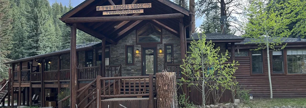 Rustic lodge entrance with a covered porch and wooden railings