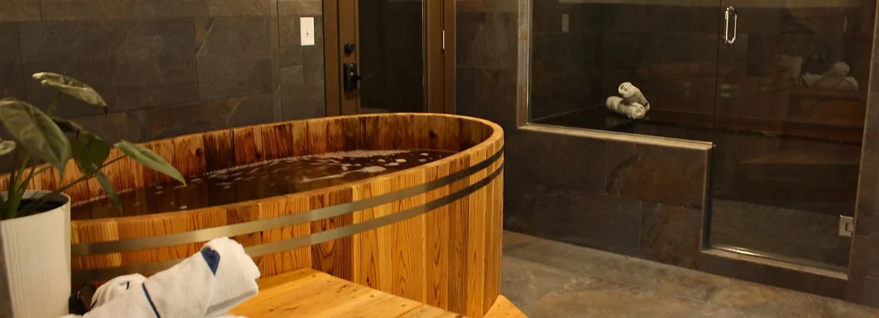 Wooden soaking tub and glass shower in a modern bathroom