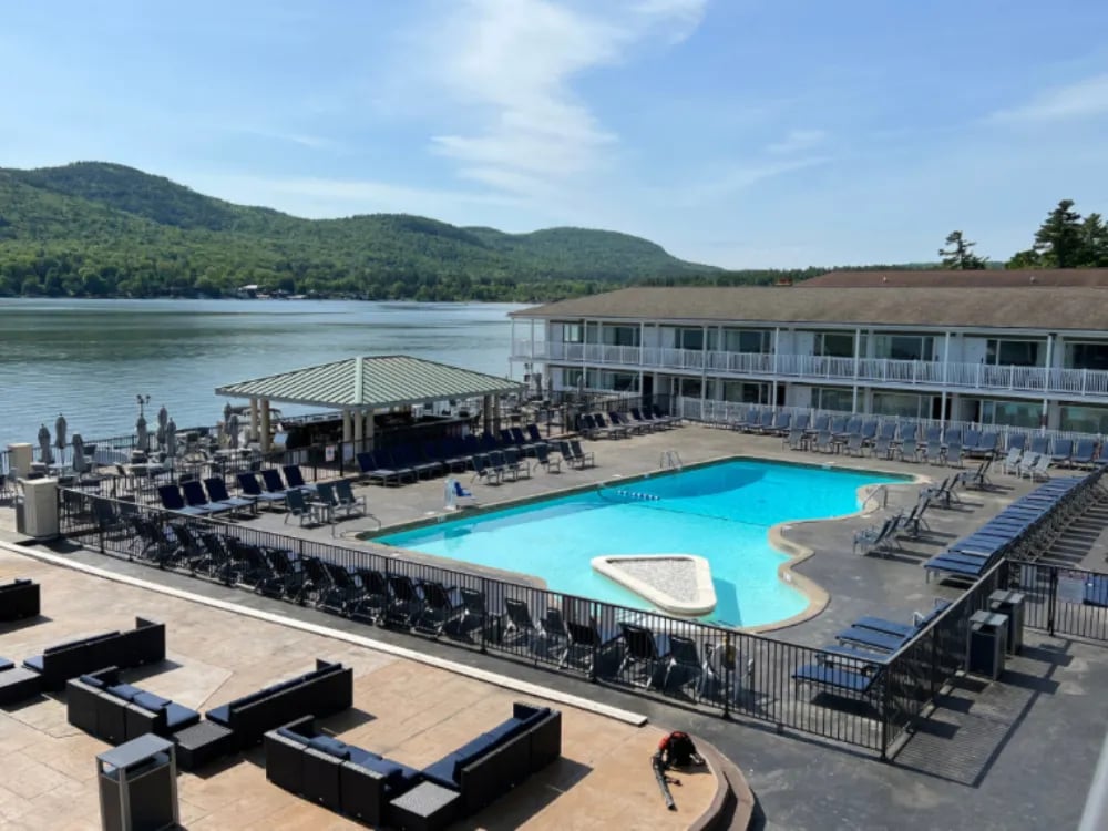 Aerial view of the Georgian Lakeside Resort pool area, cabana bar, lake, and mountains