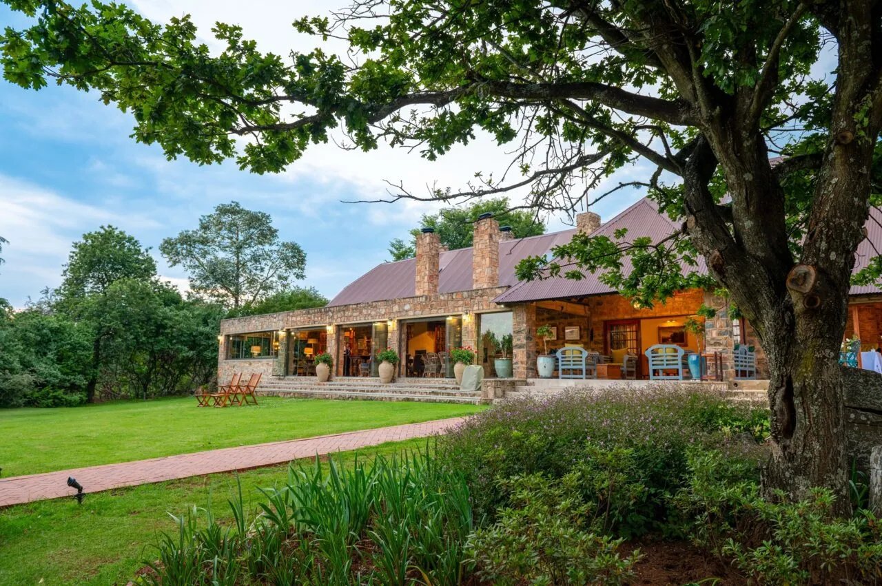 Stone building exterior with a central circular fountain and lush green foliage