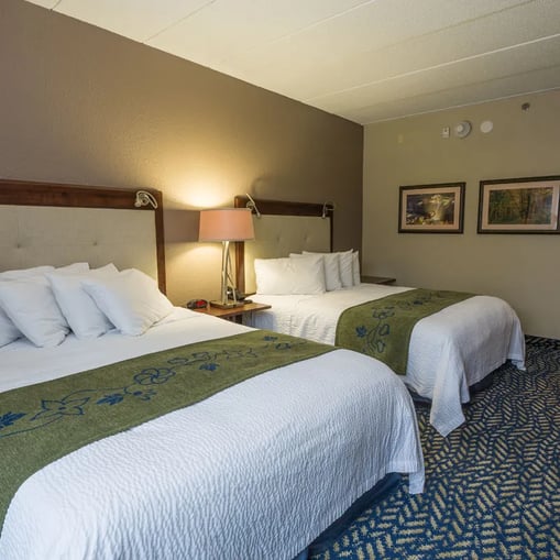 Lodge lobby with large windows overlooking a lake and comfortable seating