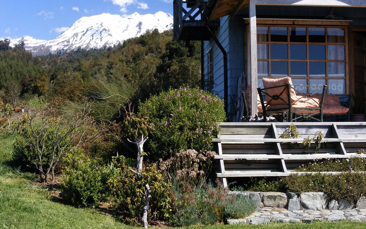 Lodge terrace and extensive gardens with snowy mountains in the background.