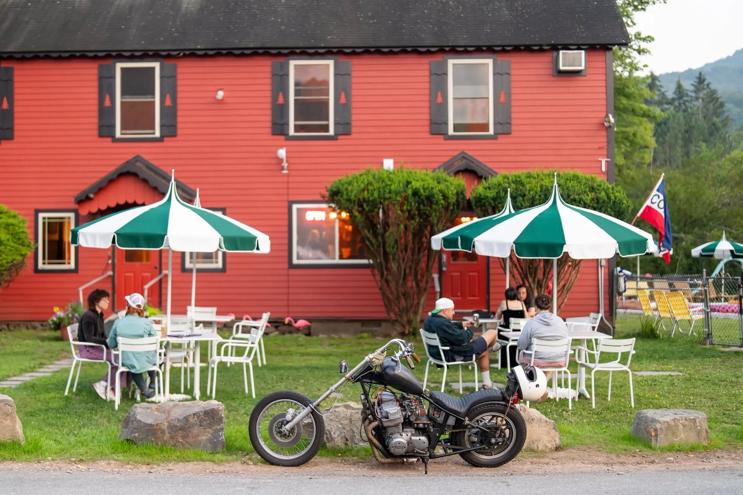 Historic brick building with a turret and porch, surrounded by modern city buildings.