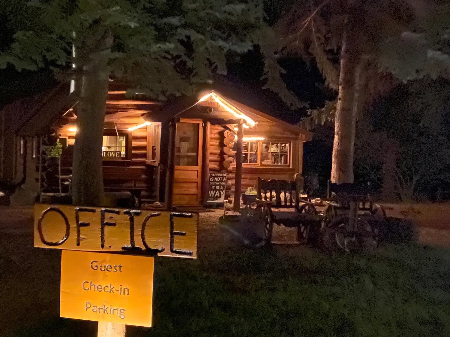 Lodge office building at night with string lights and an 'OFFICE' sign
