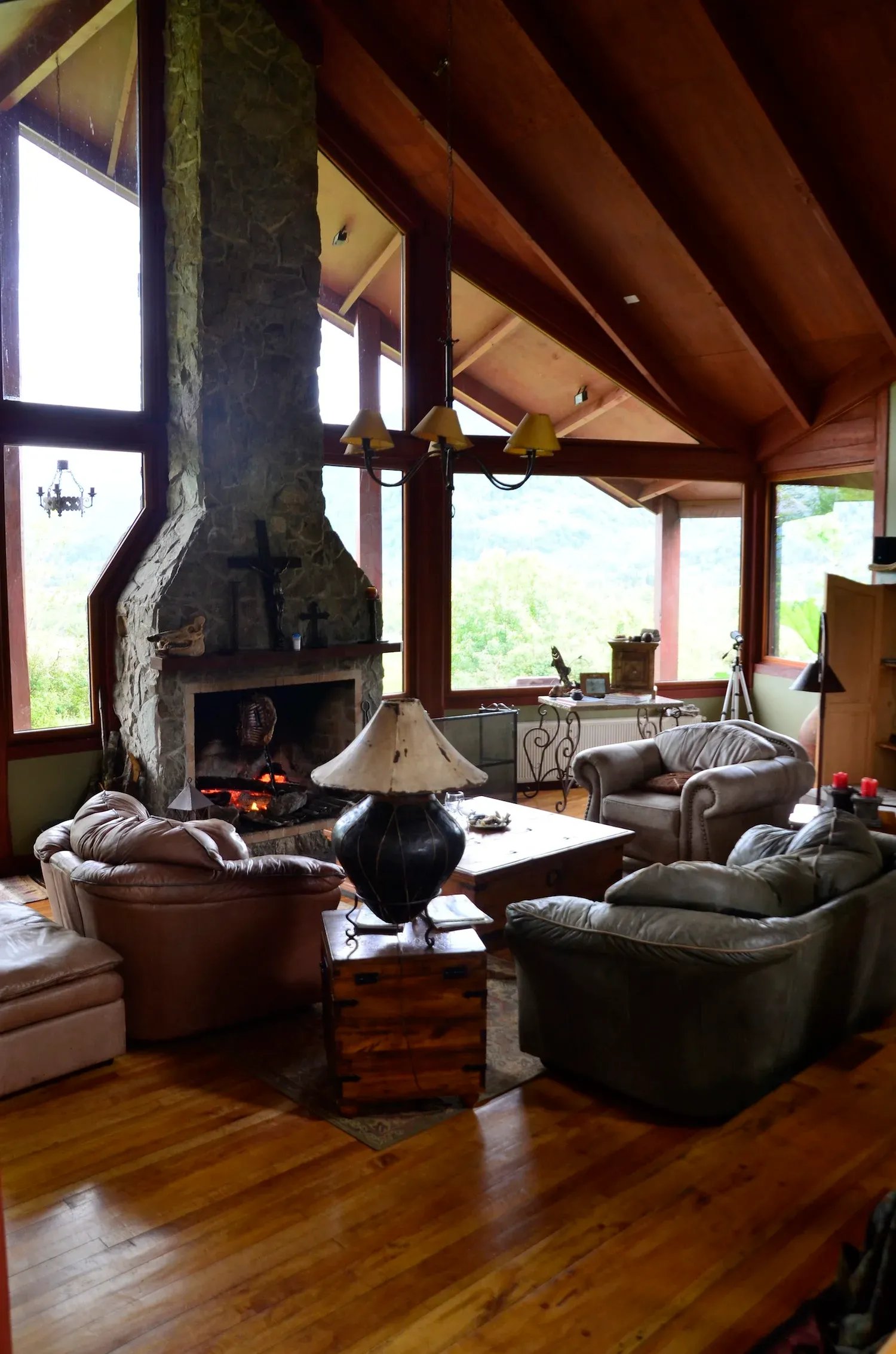 Cozy lodge common area with a large stone fireplace and vaulted wooden ceiling