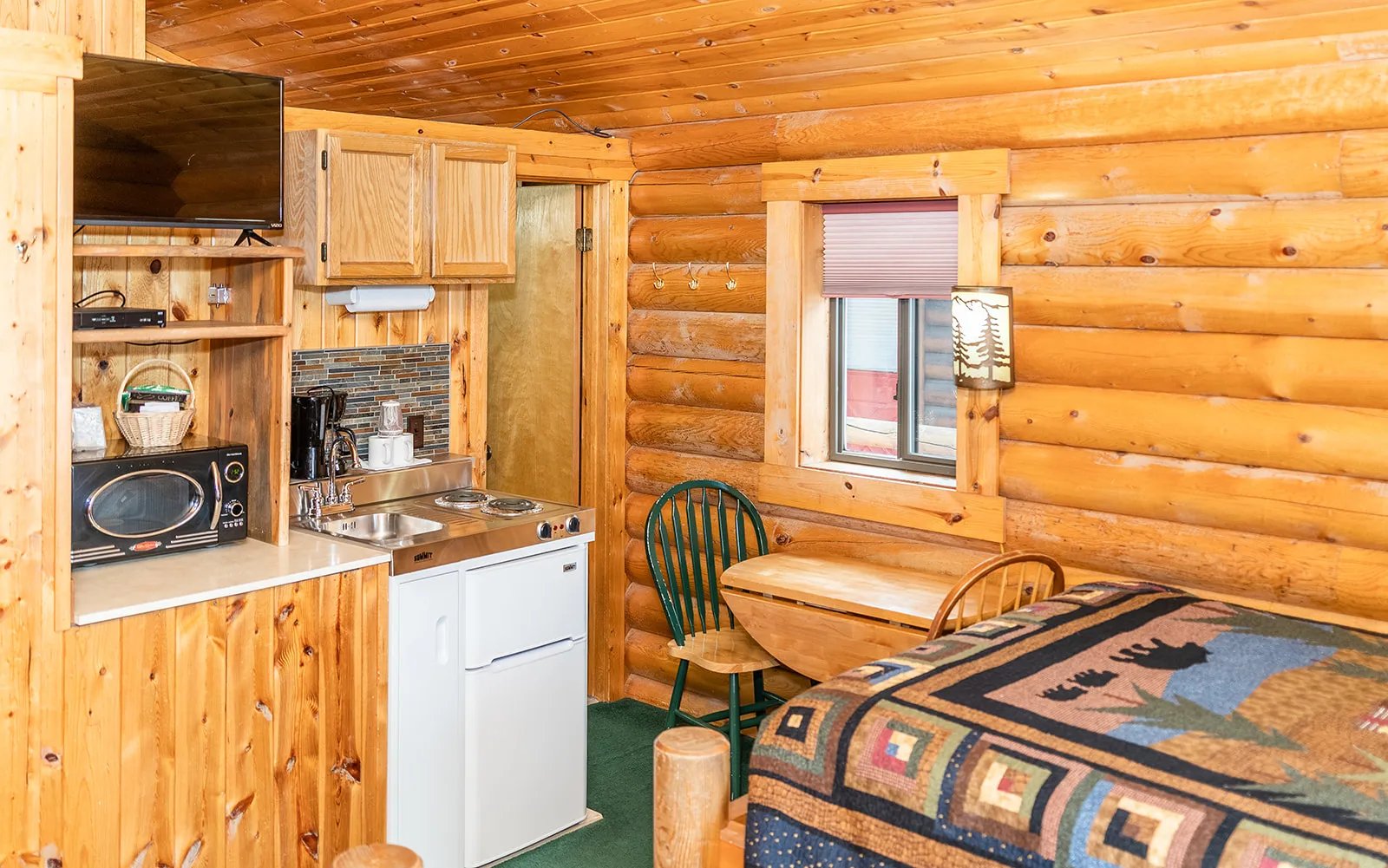 Deluxe 2 Queen Room with a queen bed, kitchenette, and log walls