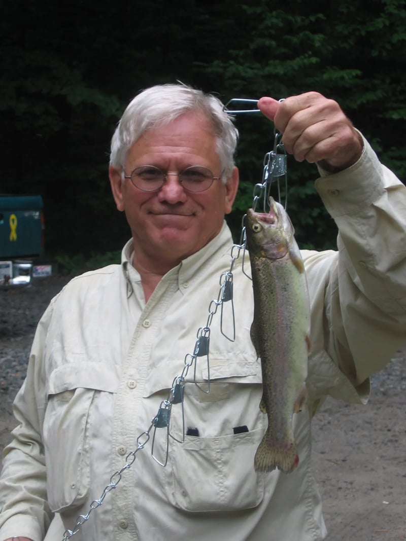 Man holding a Rainbow Trout on a stringer