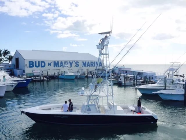 Three anglers on a boat holding a large Mahi-Mahi.