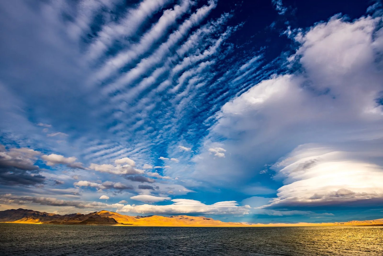 Dramatic sky with layered clouds over a vast landscape and distant mountains