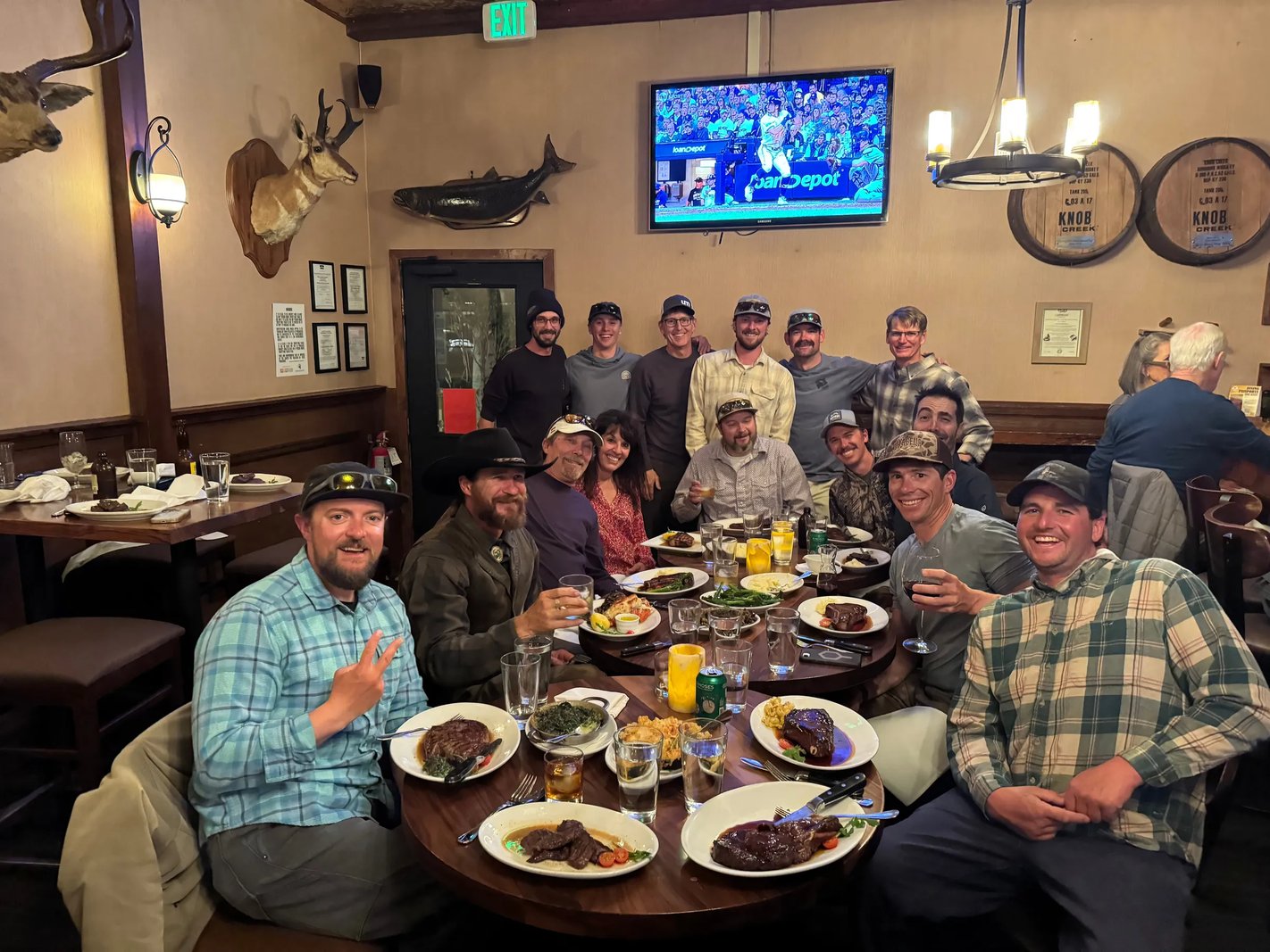 Group of fishing guides gathered around a large dinner table indoors
