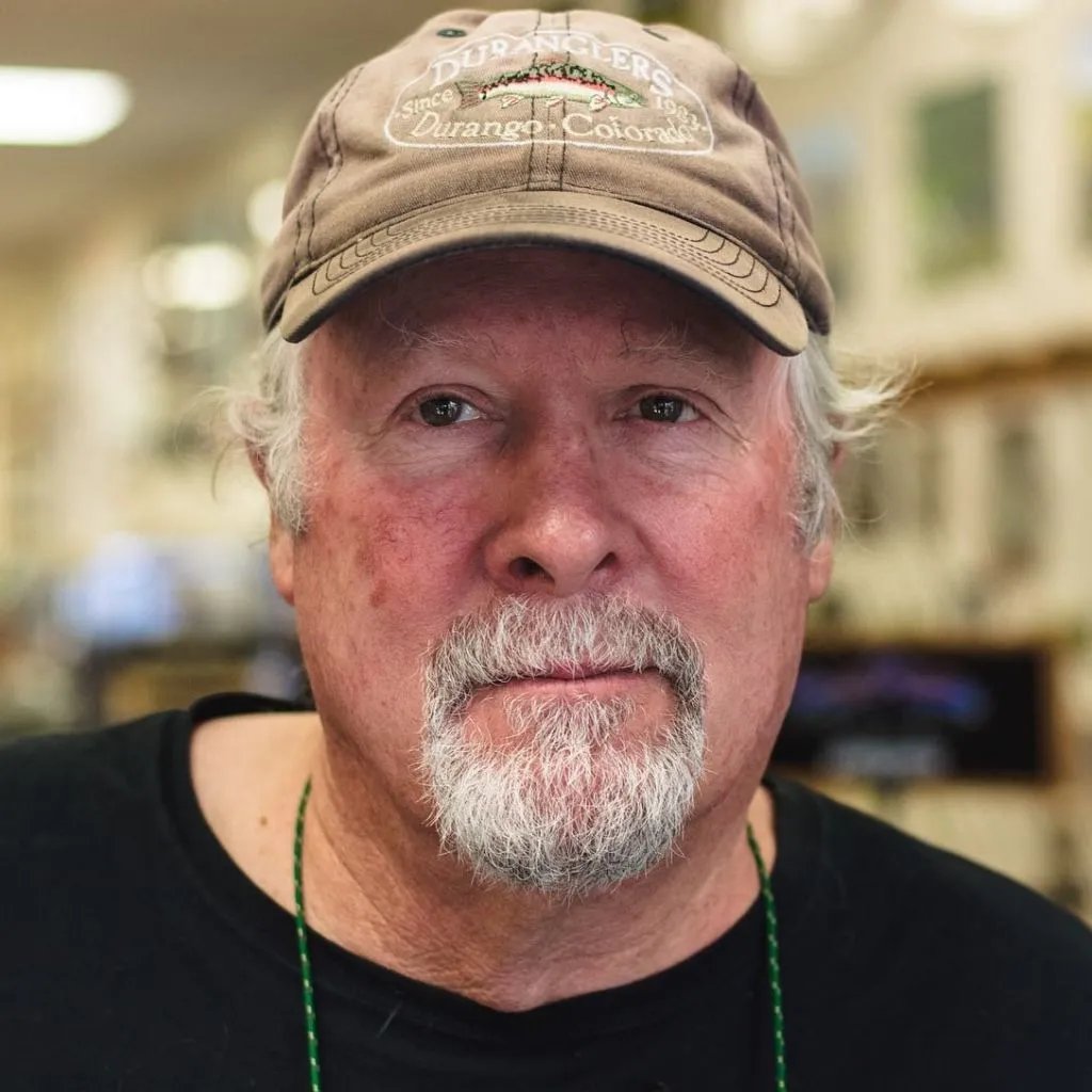 Man with a beard and a baseball cap, looking at the camera.