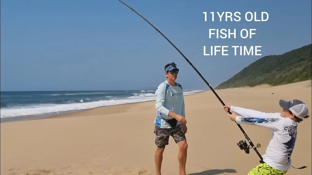 Group of anglers with fat bikes and fishing rods on a wide sandy beach.