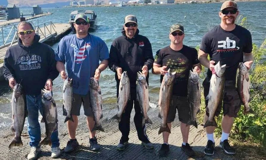 Five anglers on shore holding multiple King Salmon.