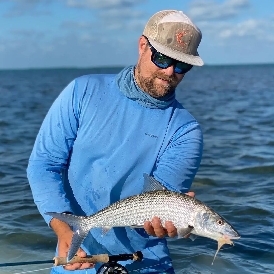 Angler holding a Bonefish in shallow water.