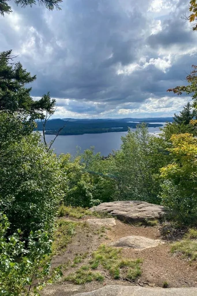 Panoramic view of a large lake surrounded by forests under a dramatic cloudy sky