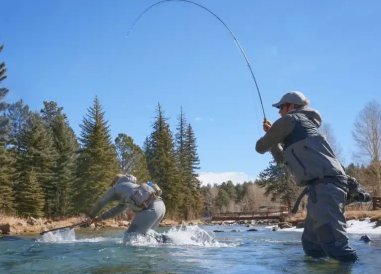Angler fighting a fish, fly rod bent sharply over the water