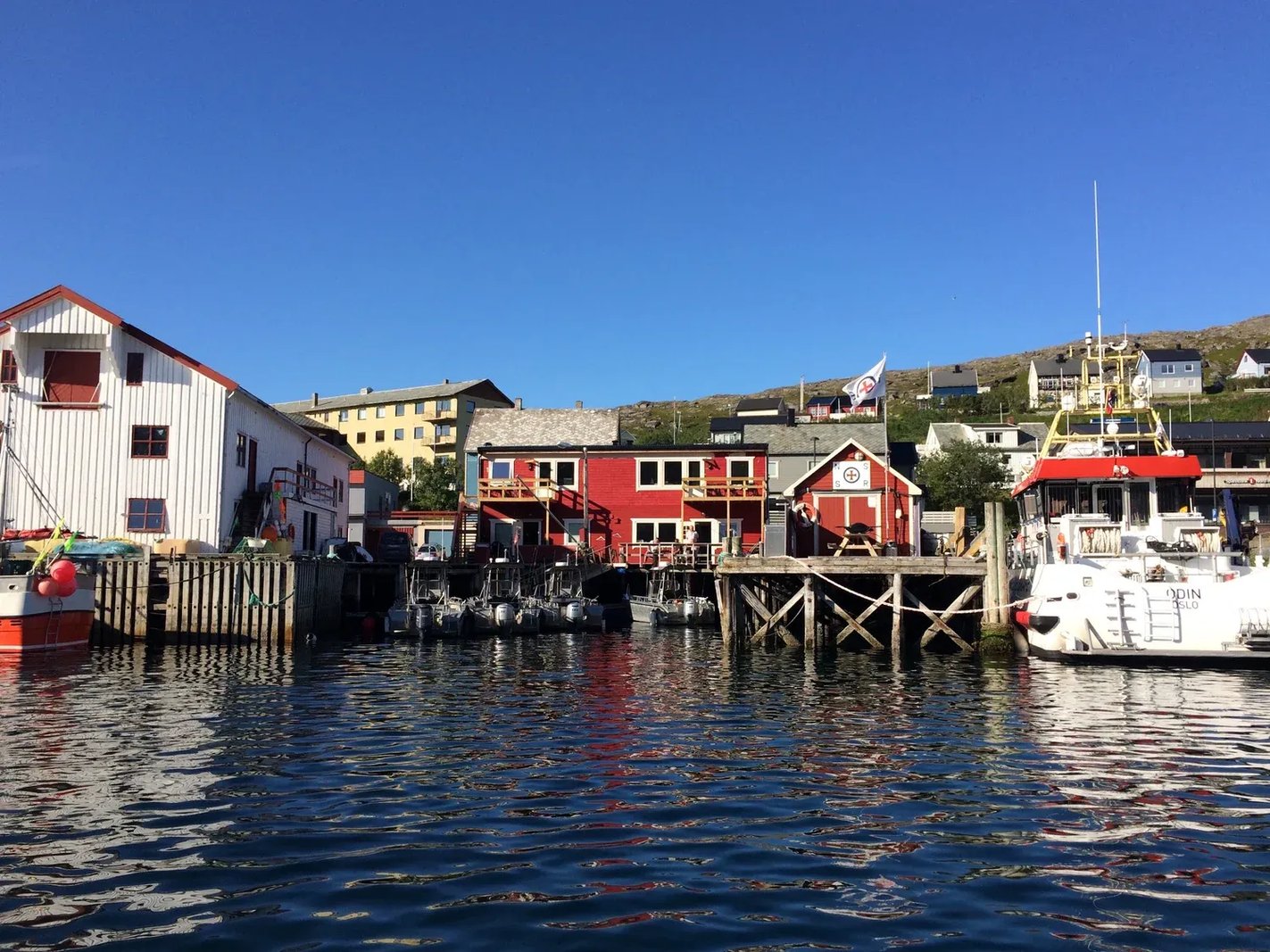 Colorful buildings and fishing boats in a bustling harbor town.
