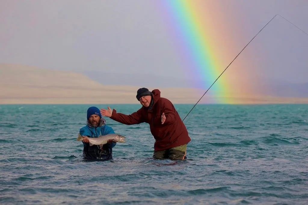 Angler smiling while holding a massive Cutthroat Trout in the lake.