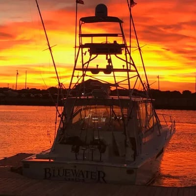 Boat at dock against a vibrant orange and yellow sunset.