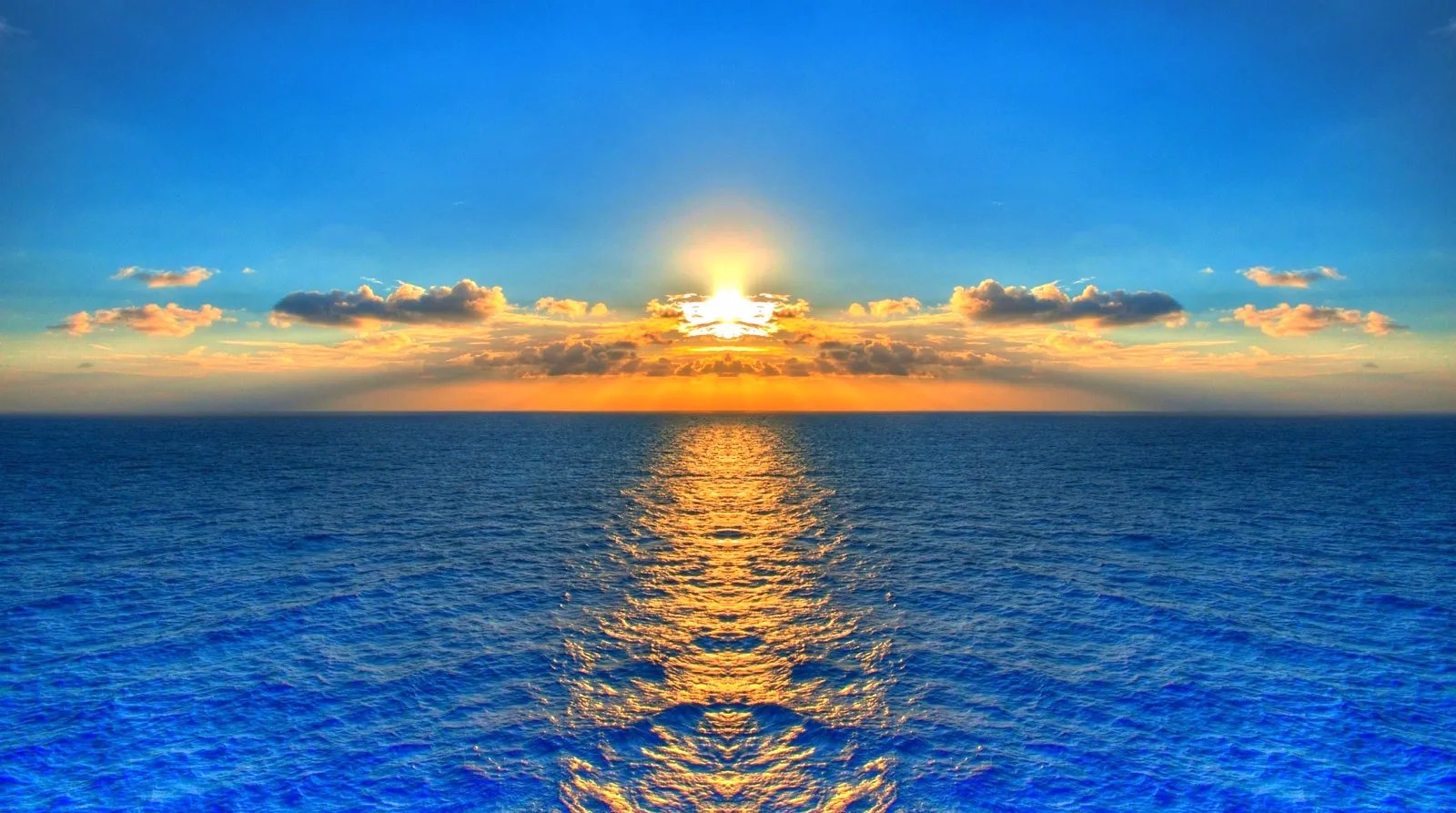 Bright sunset over a calm ocean with a golden reflection on the water
