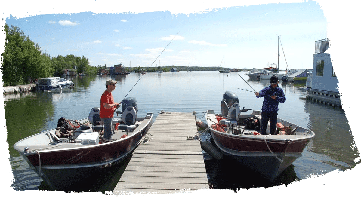 Two fishing boats docked at a wooden pier with anglers on board