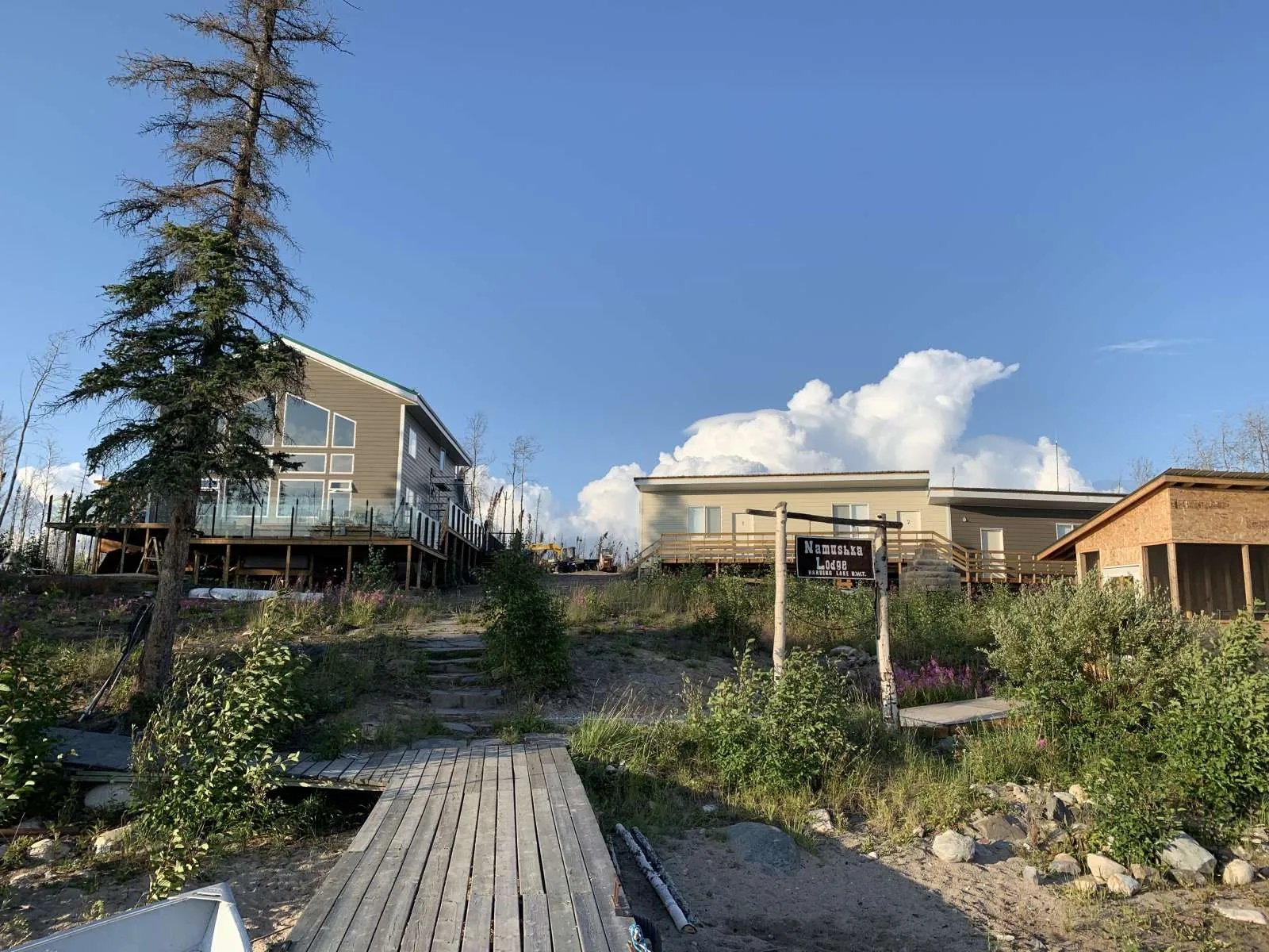 Namushka Lodge buildings on a hill, seen from a wooden walkway leading to the lake