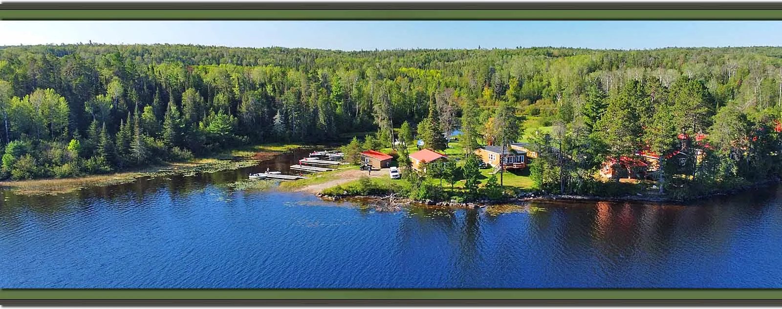 Aerial view of Seine River Lodge buildings nestled in a forest along a lake