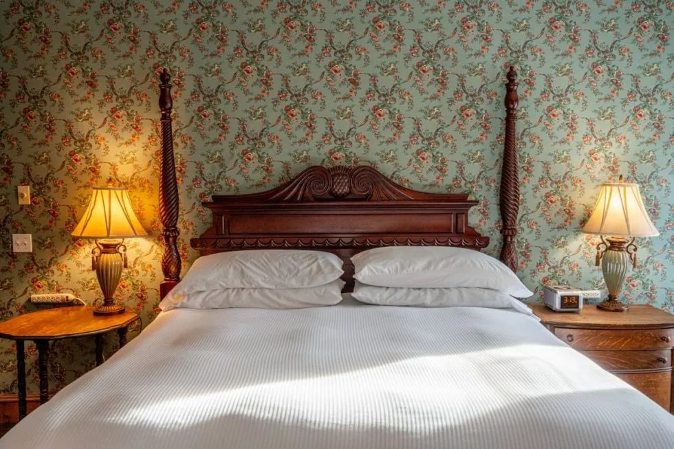 Room 3 with a four-poster bed, blue floral wallpaper, and a bay window with seating.