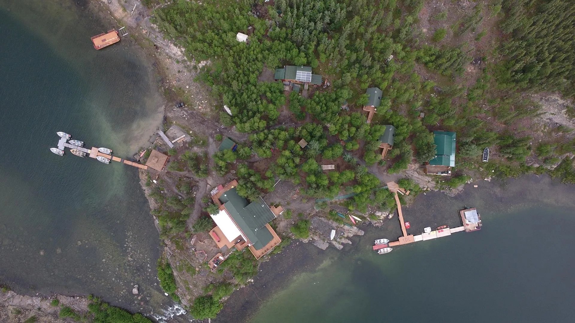Aerial view of Yellow Dog Lodge buildings and docks on a tree-lined lake shore