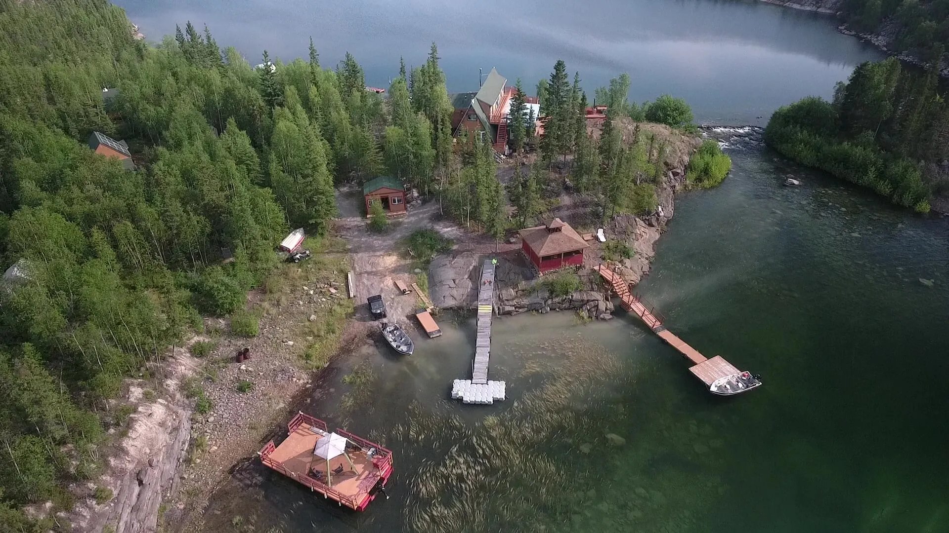 Aerial view of Yellow Dog Lodge buildings and docks on a rocky, tree-covered peninsula