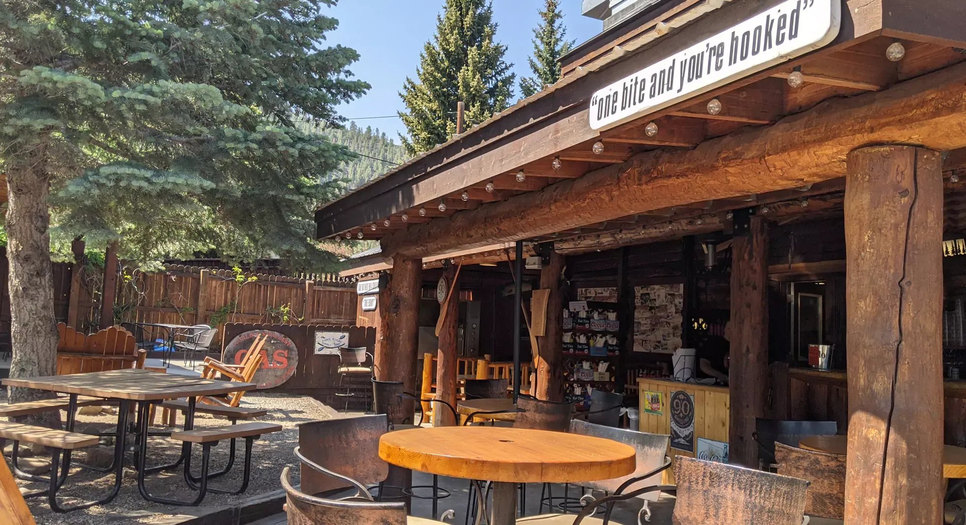 Three Rivers Smokehouse exterior with outdoor picnic tables under trees