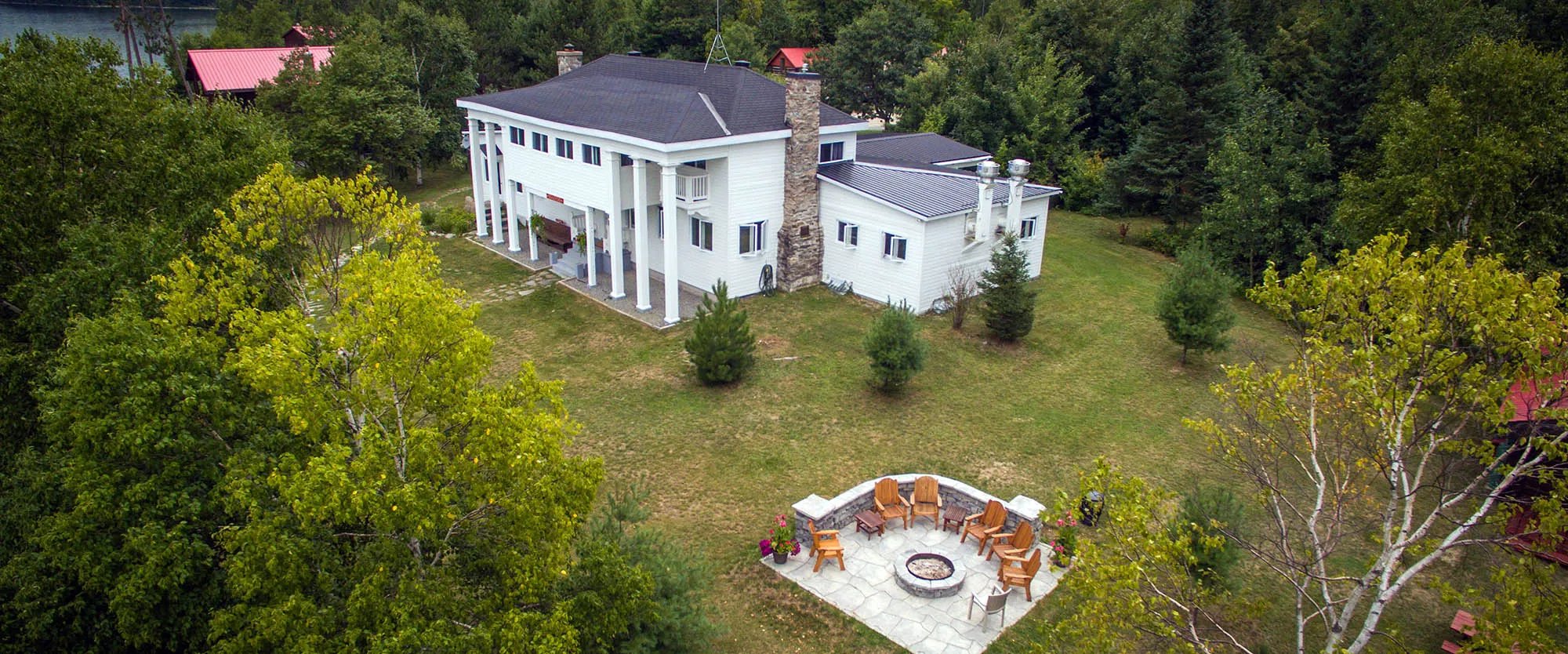 Aerial view of the white main lodge and a stone fire pit area