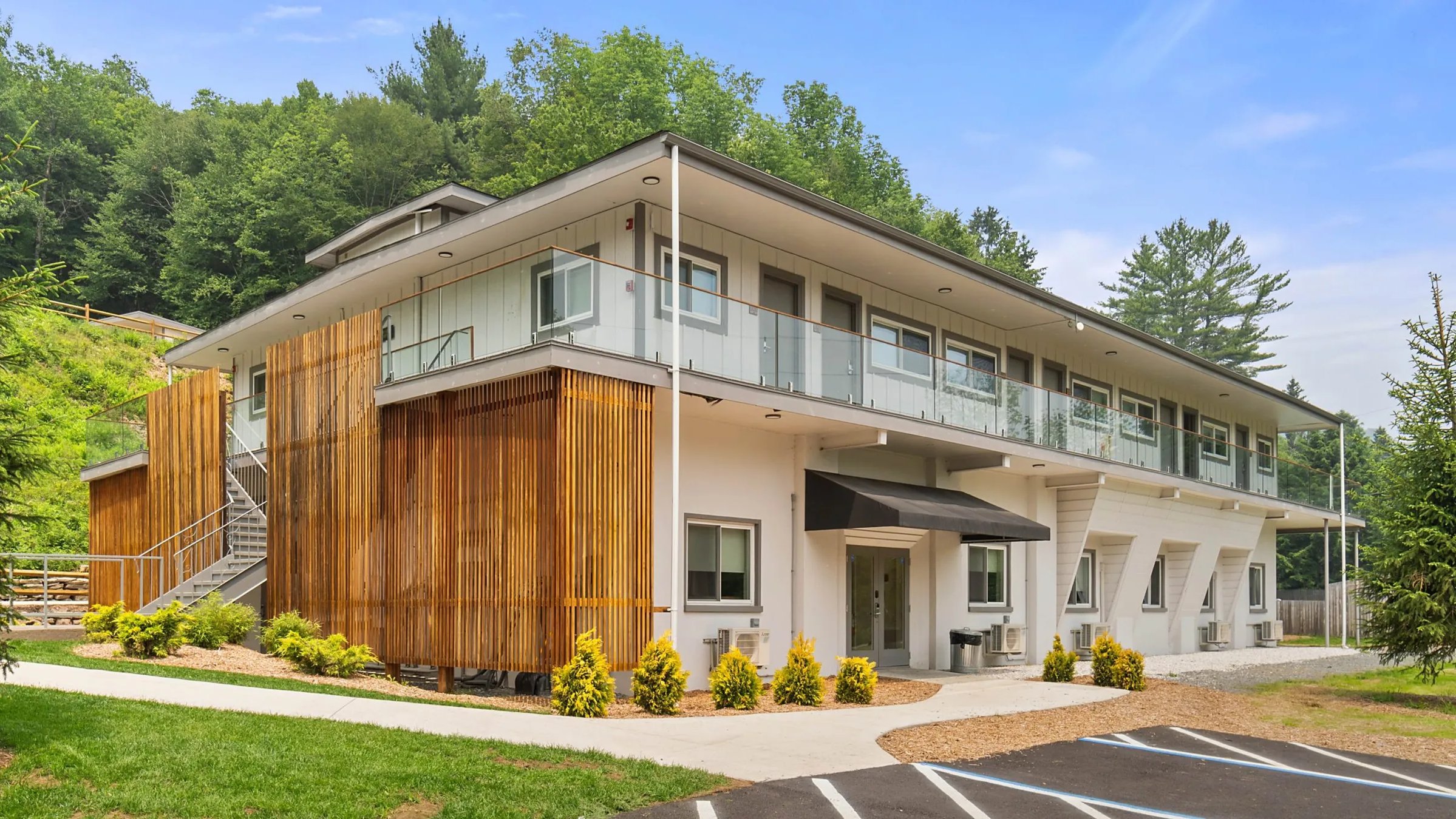 Grand white Boarding House lodge with multiple gables and a wide front porch on a green lawn