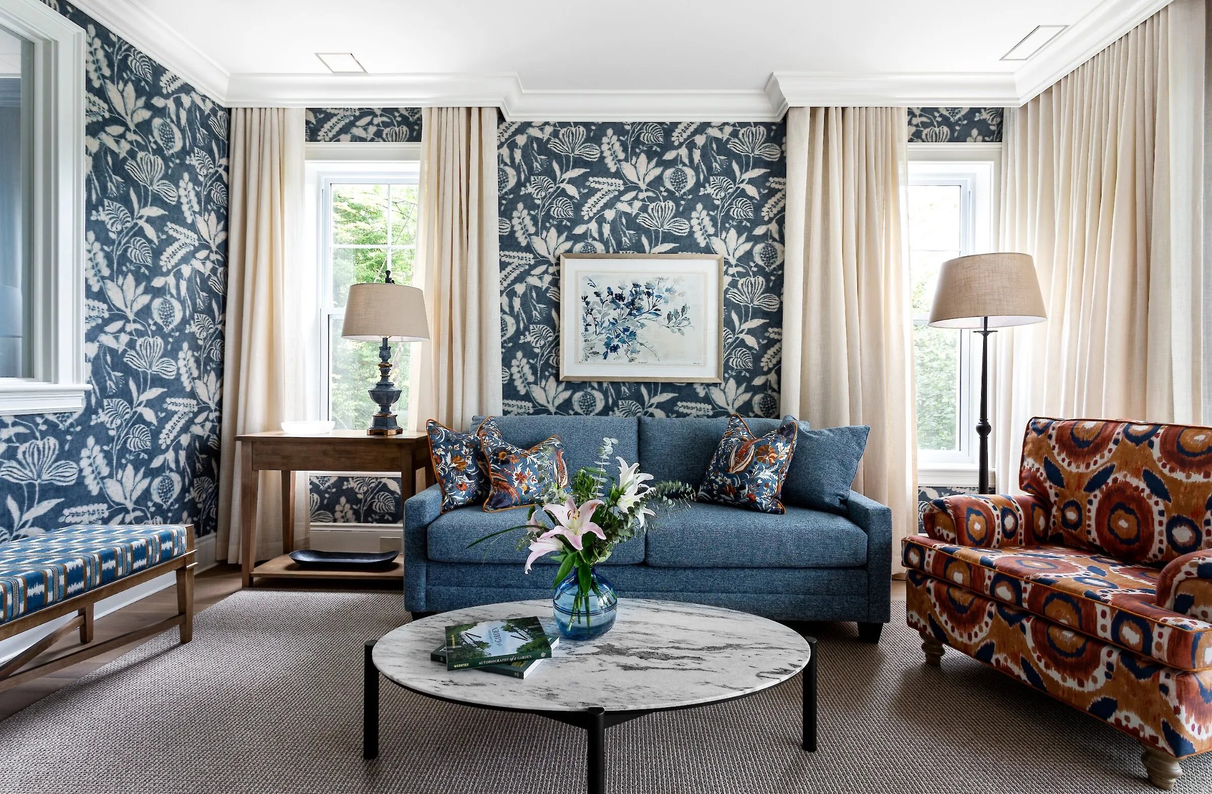 A living room with several sofas and windows