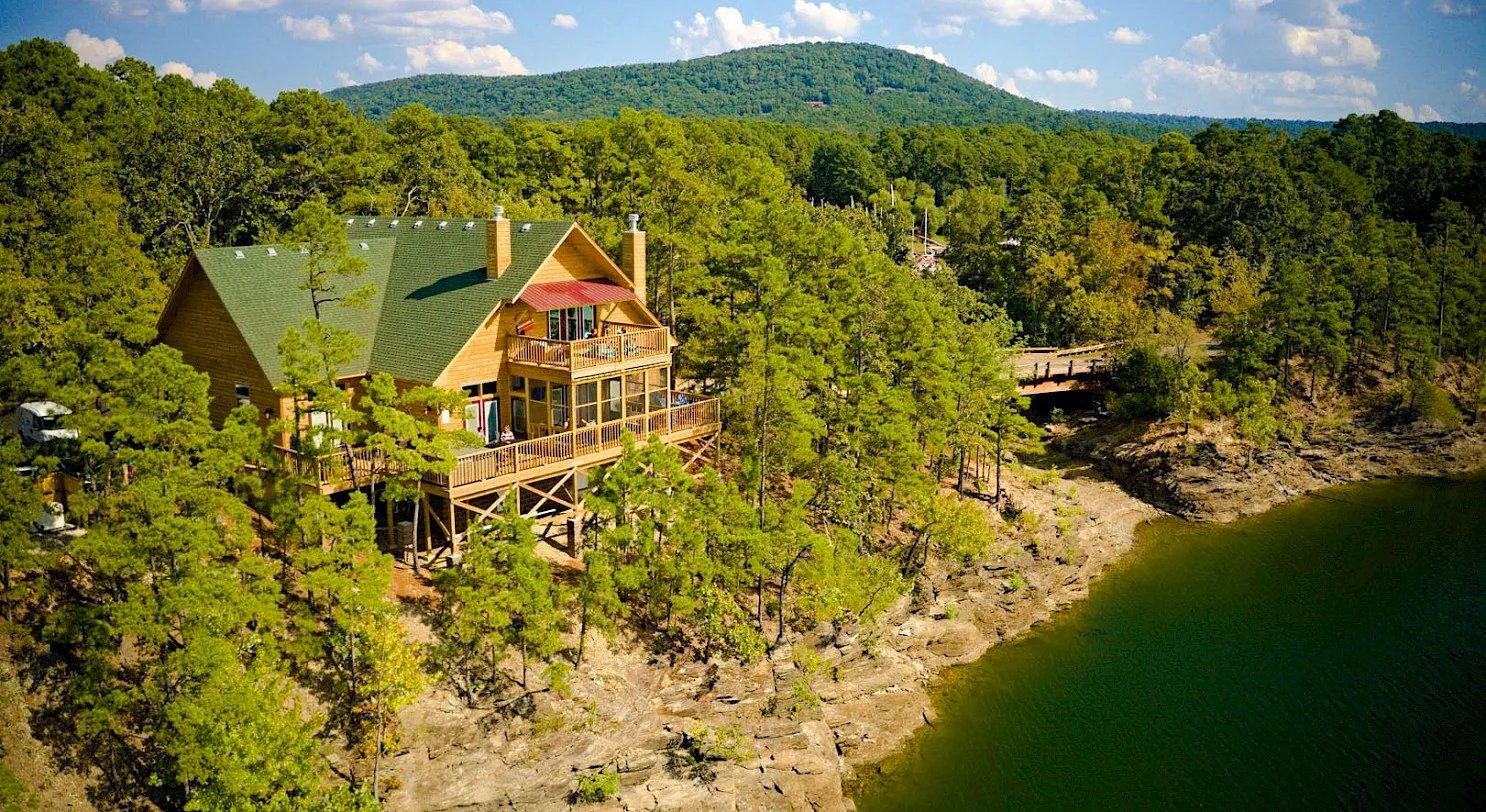 Lodge buildings and parking area in a wooded setting on a sunny day