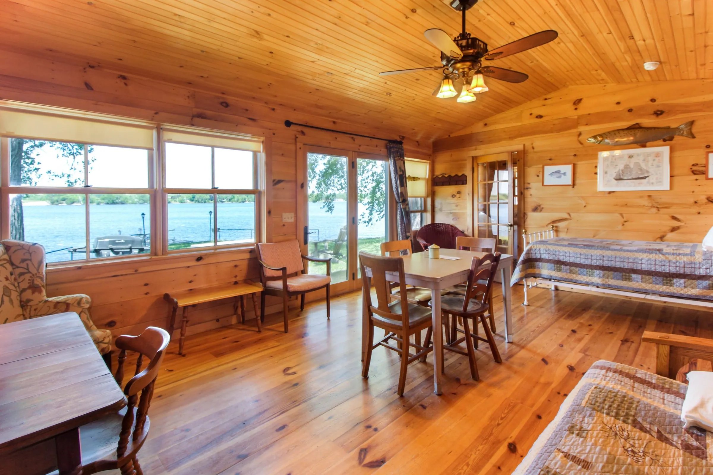 Lakeside 2-bedroom cabin interior with wood paneling, dining table, and lake view