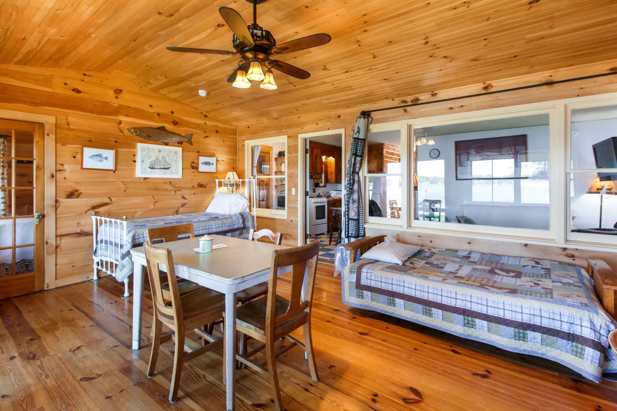 Lakeside 3-bedroom cabin interior with wood paneling, dining table, and daybed