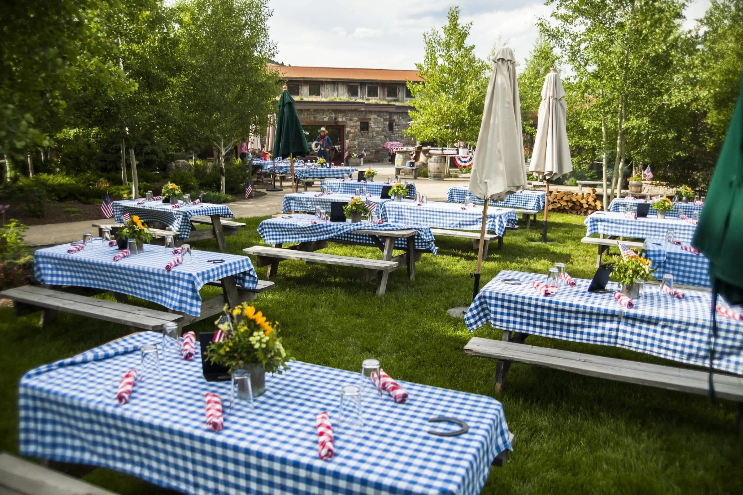 Many picnic tables set up on the flagstone lawn set for an event